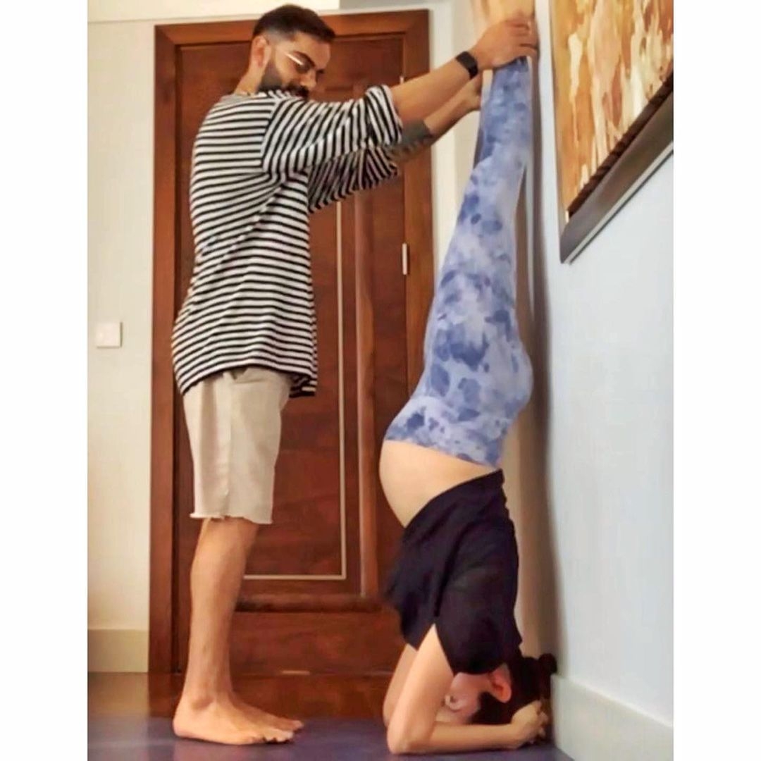Pregnant Anushka Sharma performs Shirshasana with Virat's support.