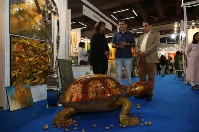 An artist explains his artwork as India Art Festival Director Rajendra and chef Sanjeev Kapoor look on at the India Art Festival 2020.